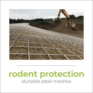 A steel mesh on a dike, in the background a yellow excavator